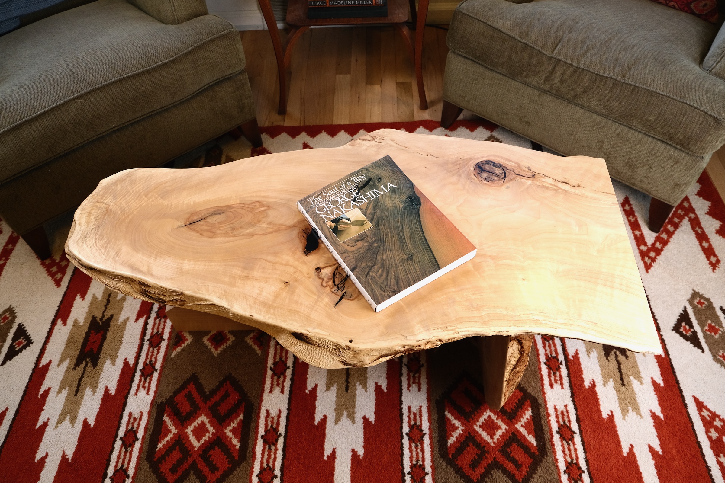 House Coffee Table #1 in a living room, with George Nakashima's The Soul of a Tree resting on the slab top